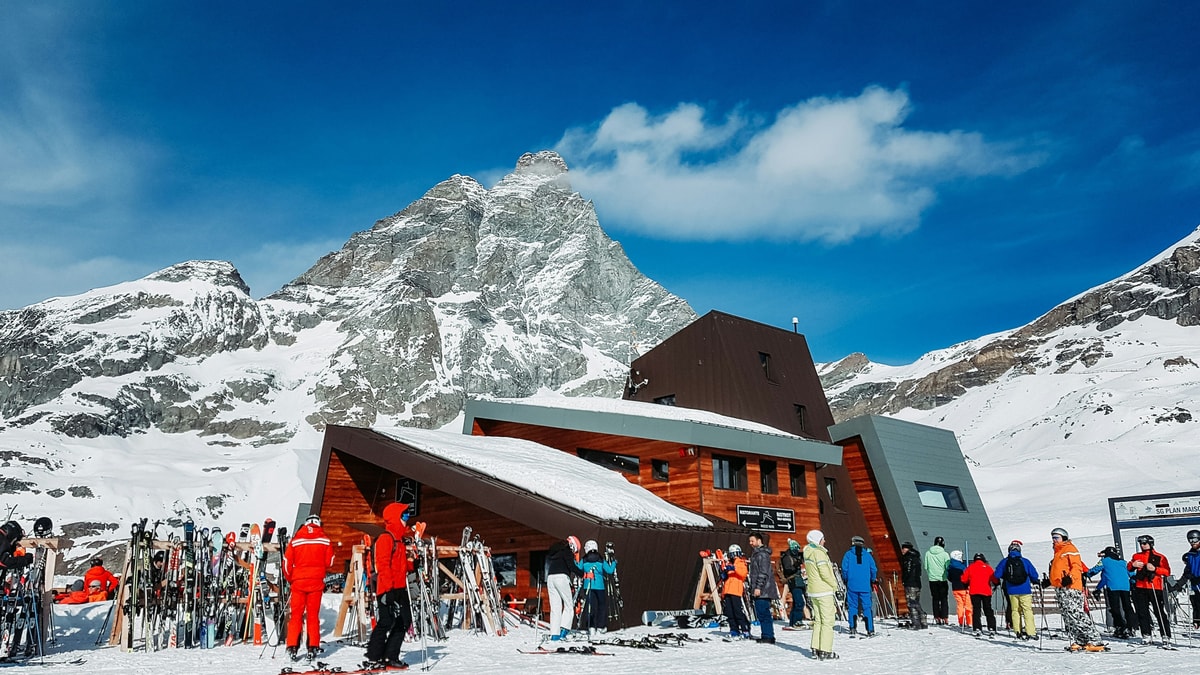 Skiers outside a mountain restaurant at Rocce Nere, with the Matterhorn above Breuil-Cervinia